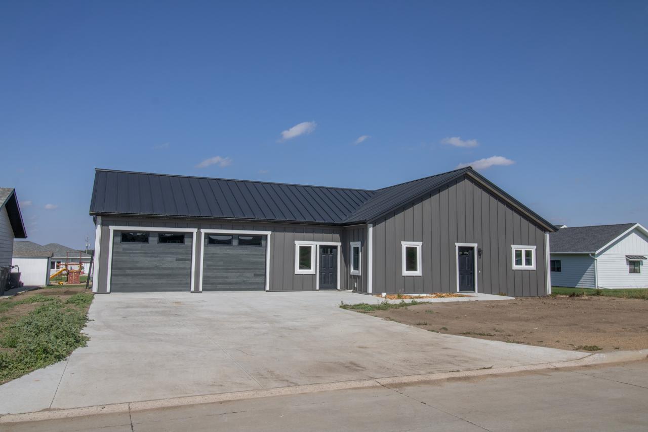 Black and Quaker Grey post-frame barndominium with an attached two-car garage, built by Hoksbergen & De Stigter Construction